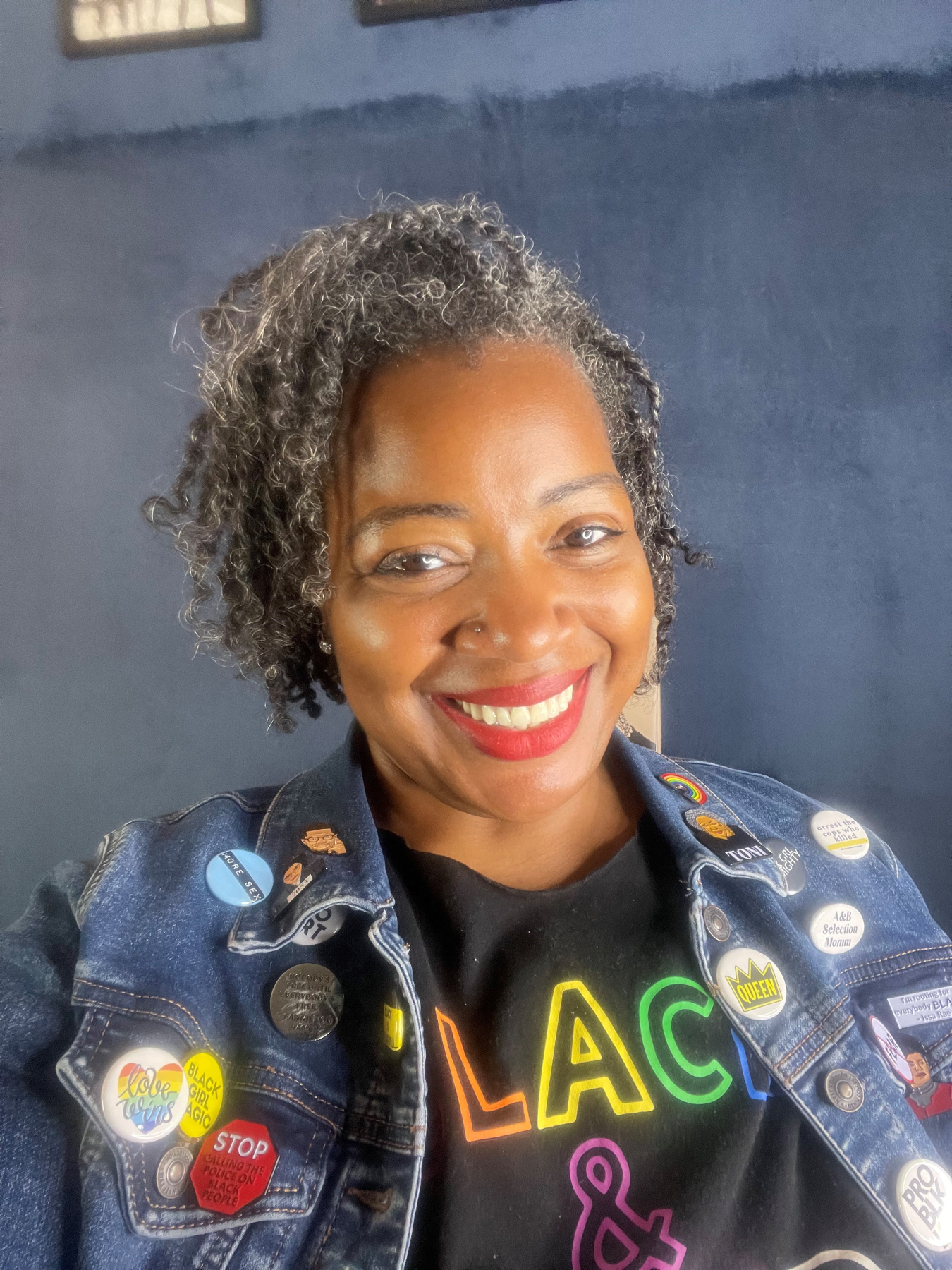 A photo of Heather Lee Anne Owens, with multiple pins for different causes on her jacket.