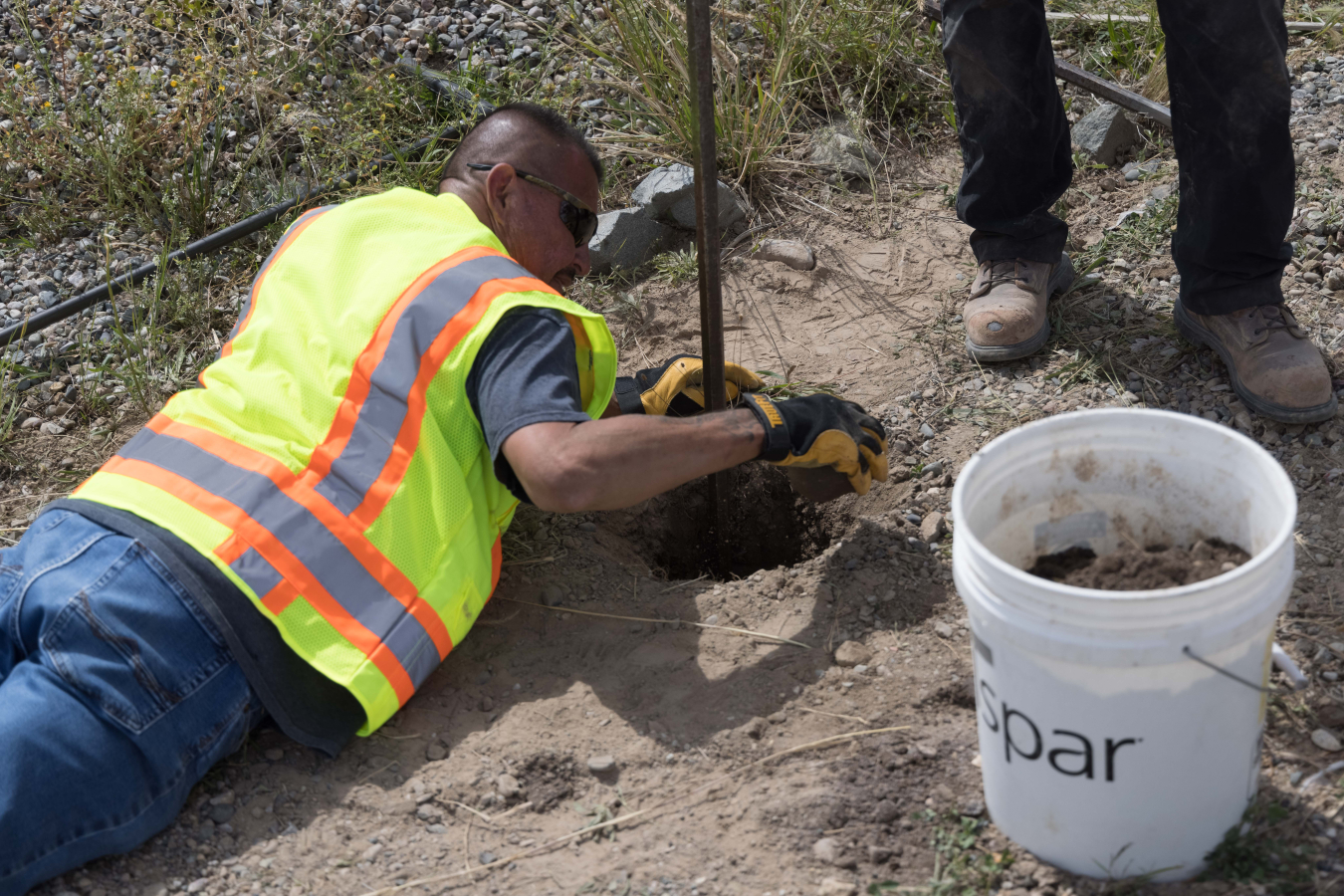 A Newport News Nuclear BWXT-Los Alamos (N3B) employee collects a soil sample for analysis of potential contaminants associated with historical operations at Los Alamos National Laboratory (LANL).