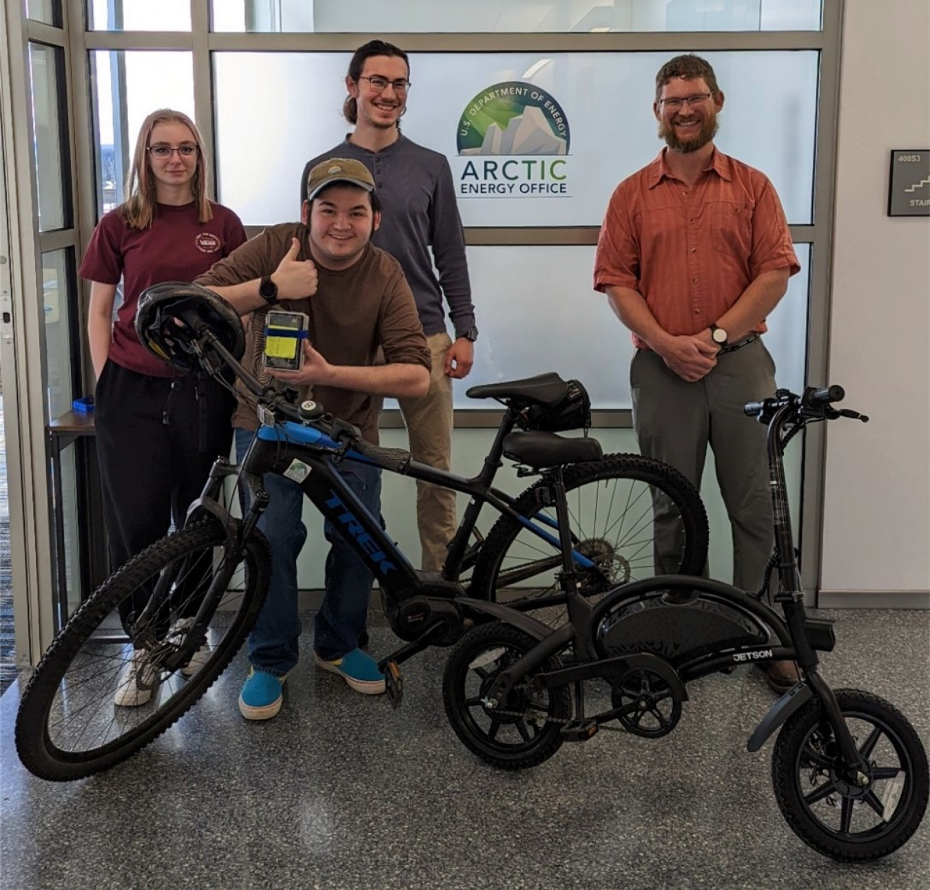 University of Alaska students pose with e-bikes outside the Arctic Energy Office. on in Fairbanks. 