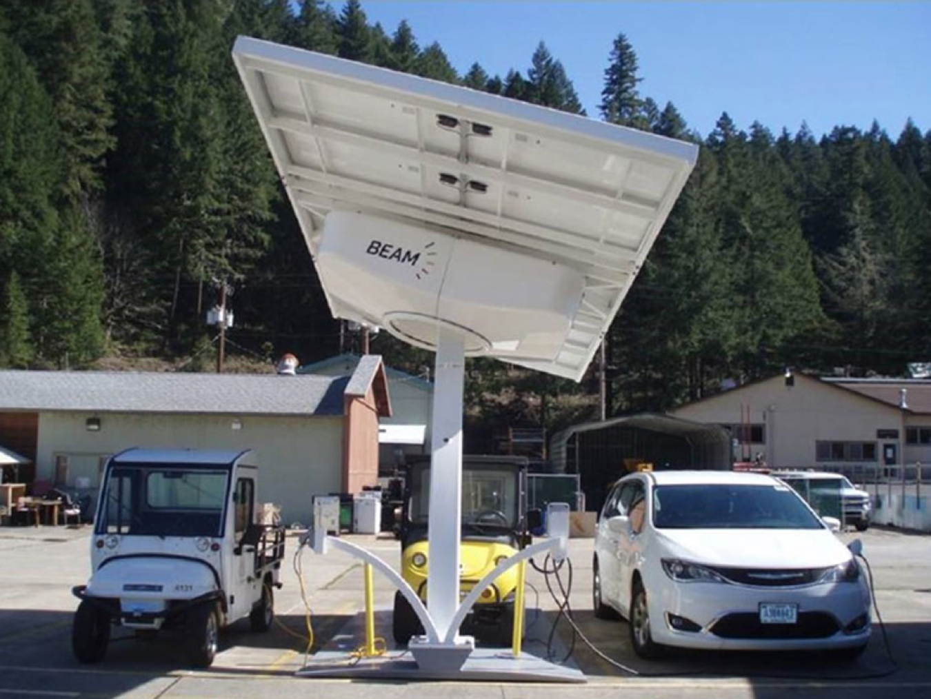 Two electric vehicles plugged in at a charging station.