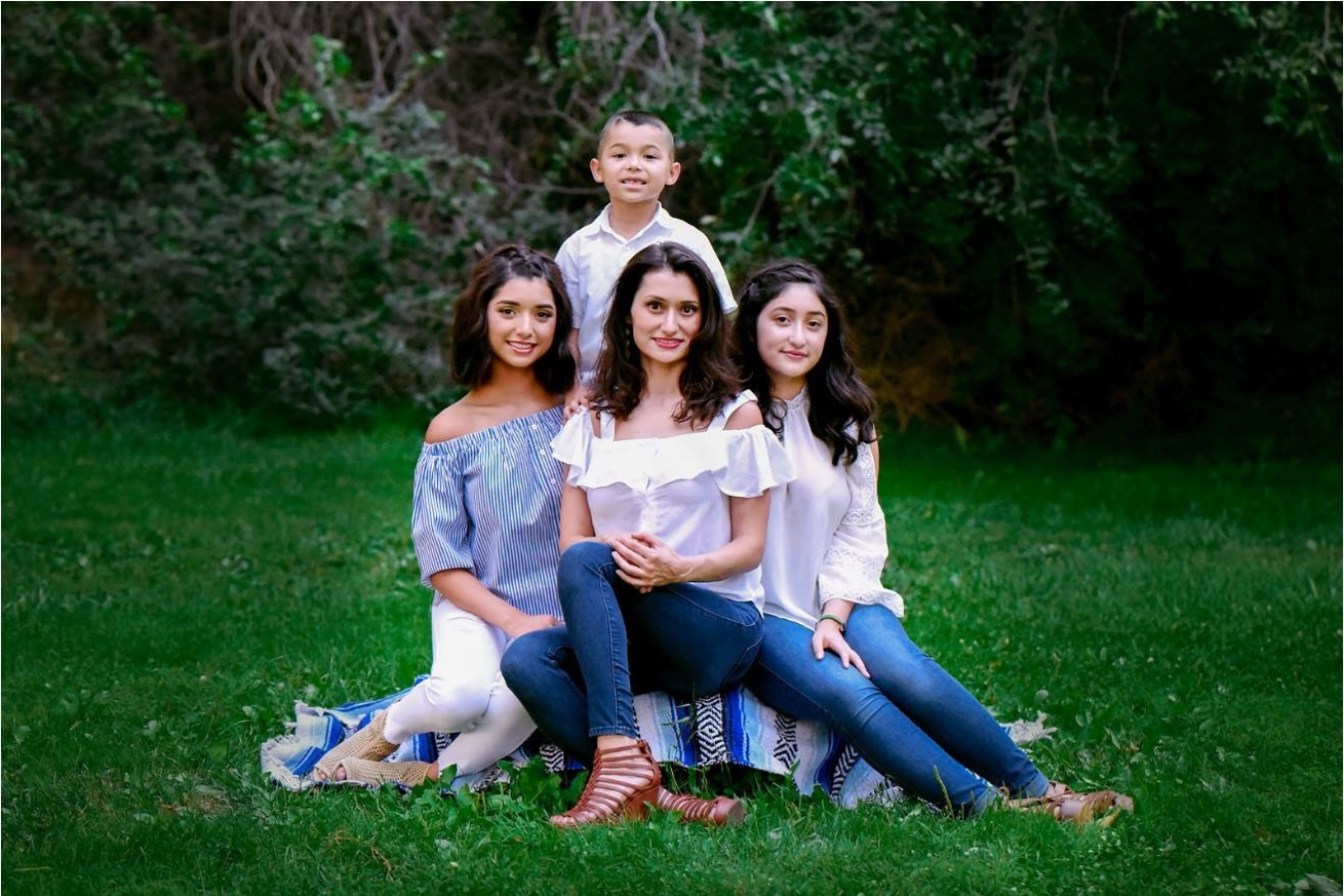 Alma Contreras with her three children, outside.