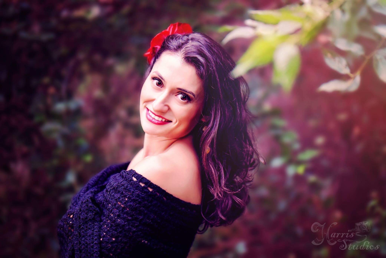 A photo of Alma Contreras outside, framed by leaves.