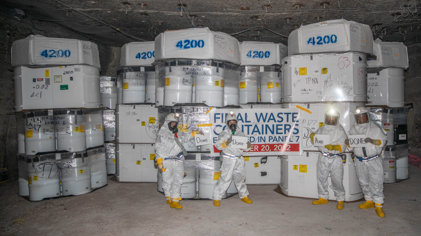 Waste handlers pause for a photo in front of the last transuranic waste containers to be emplaced in Panel 7 of the Waste Isolation Pilot Plant underground.