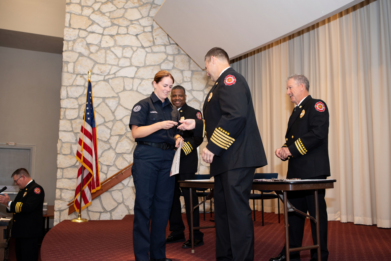Firefighter Christina Aamodt receives her badge from Chief Todd Roper during a Hanford Fire Department ceremony recognizing graduates of the New Recruit Training Academy, a 16-week training course covering a range of courses and hands-on fire training.