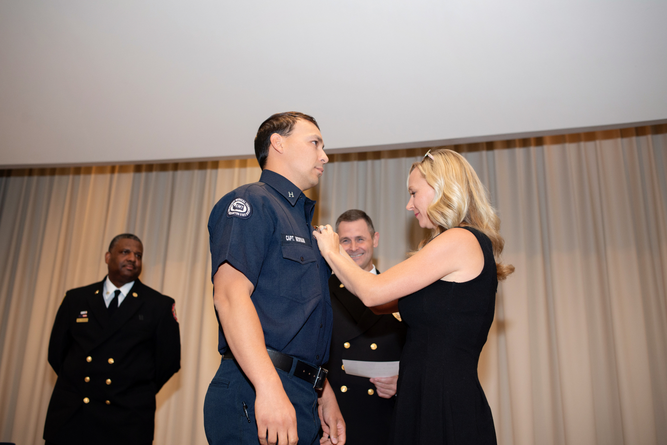 Capt. David Newman receives his promotional pin from his wife, Karen, during a ceremony held by the Hanford Fire Department recognizing individuals who received promotions between 2019 and 2022.