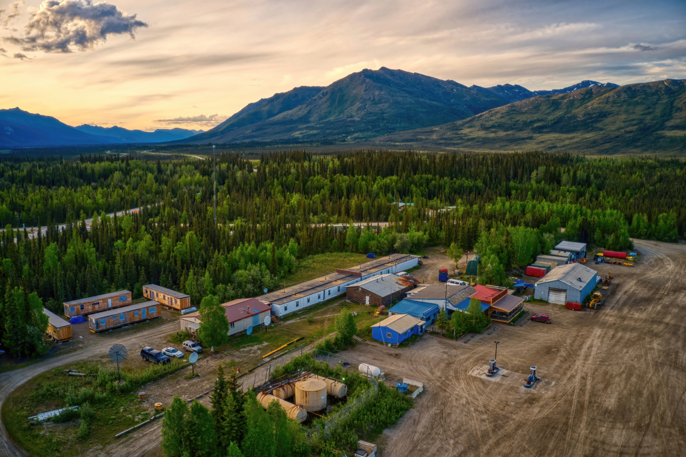 Arial view of a rural/remote community, mountains and forest in the background.