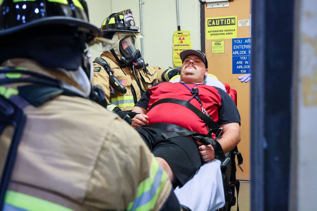 Waste Isolation Pilot Plant (WIPP) firefighters and paramedics Jesse Solano, left, and Jakoda Mathews prepare to transport Nick Thompson, who portrays a victim, from the WIPP waste handling building to a waiting ambulance during a mock event as part of an annual emergency training exercise.