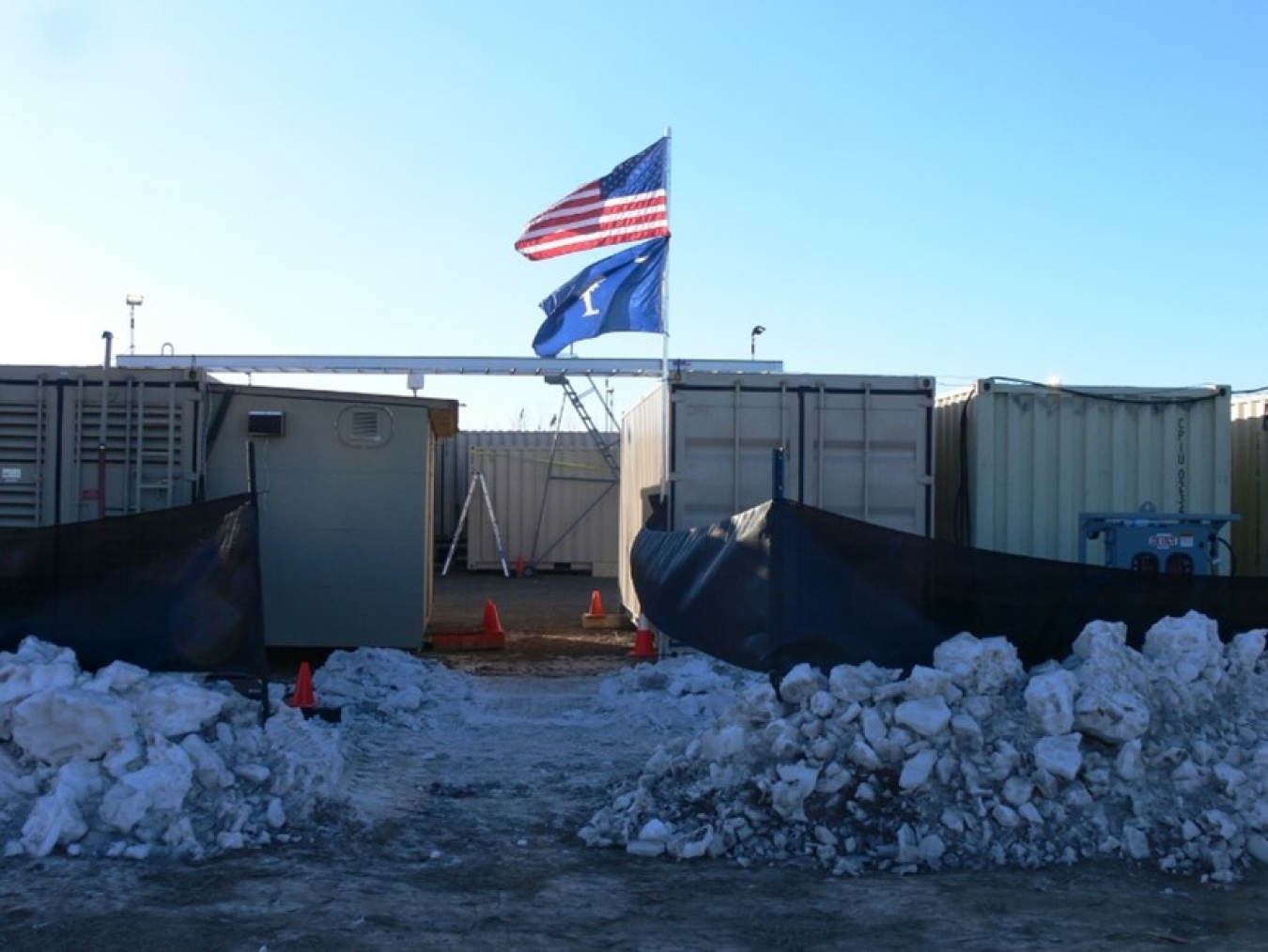 Shipping containers sit by plowed snow. The U.S. and South Carolina flags wave in the breeze.