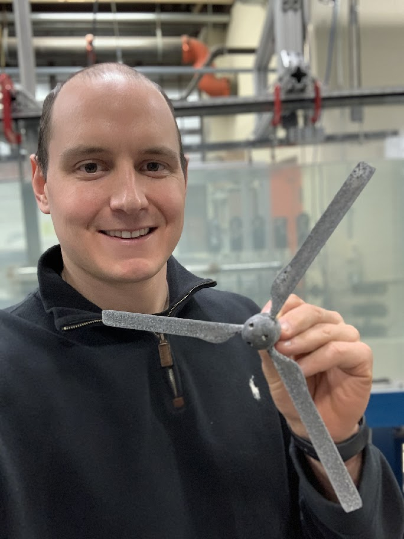 Christopher Ruhl holds up a small version of a tidal energy turbine