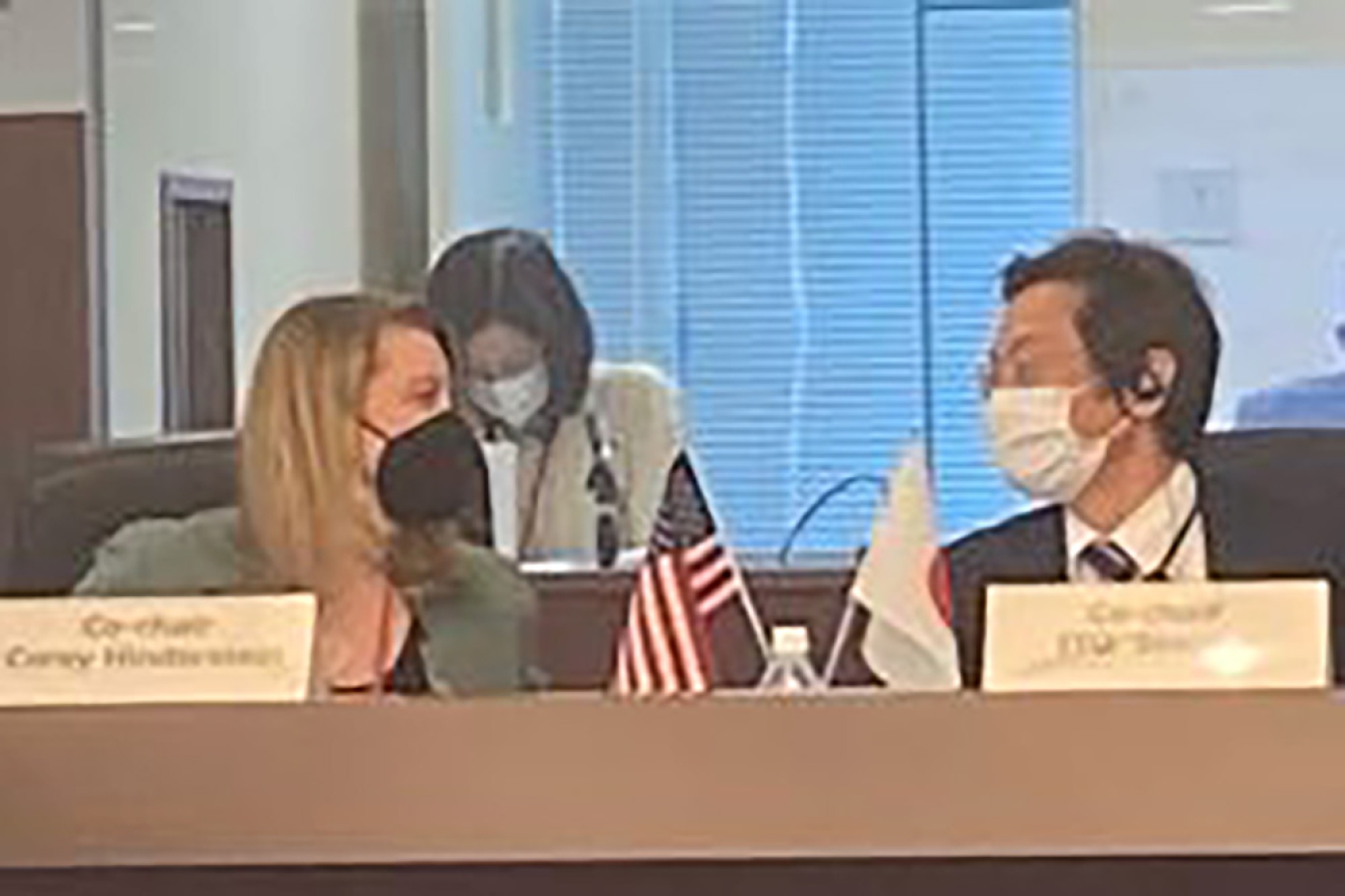 Corey Hinderstein and Shigeki Ito confer during the NSWG meeting. Both are wearing face masks.