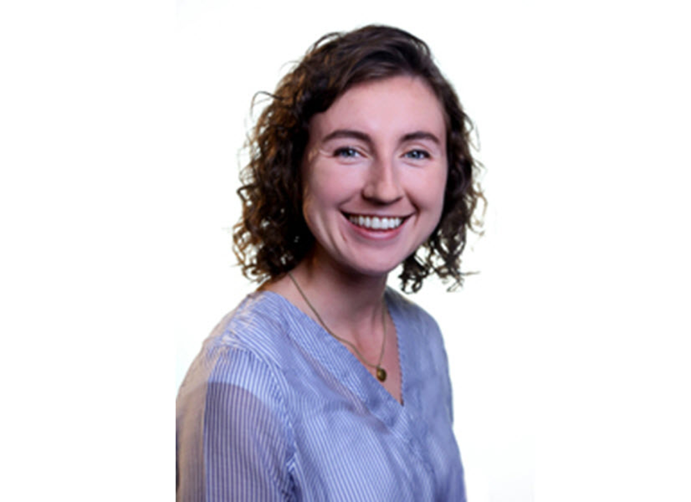 Headshot of a young woman wearing a light blue shirt. She is smiling warmly at the camera.