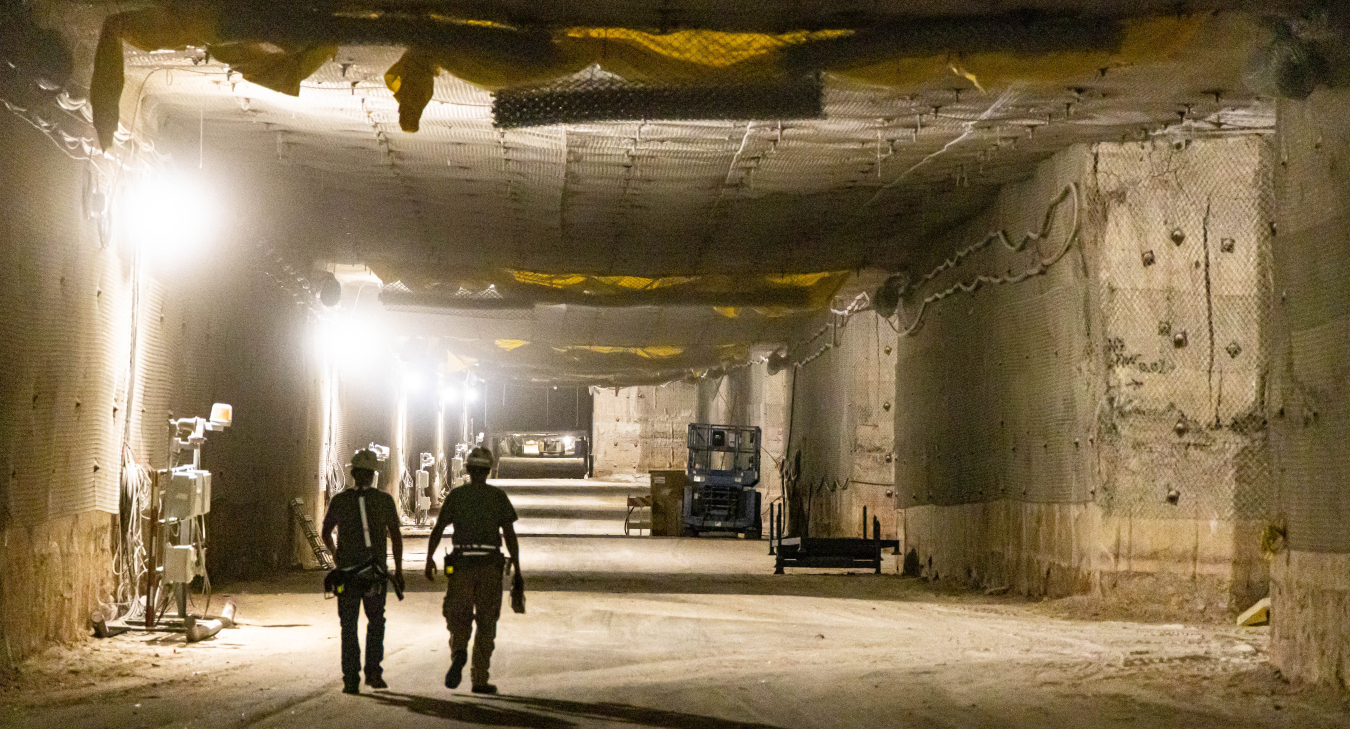 Two workers stroll down a passageway in Panel 8 at the Waste Isolation Pilot Plant after transuranic waste operations began there earlier this month.