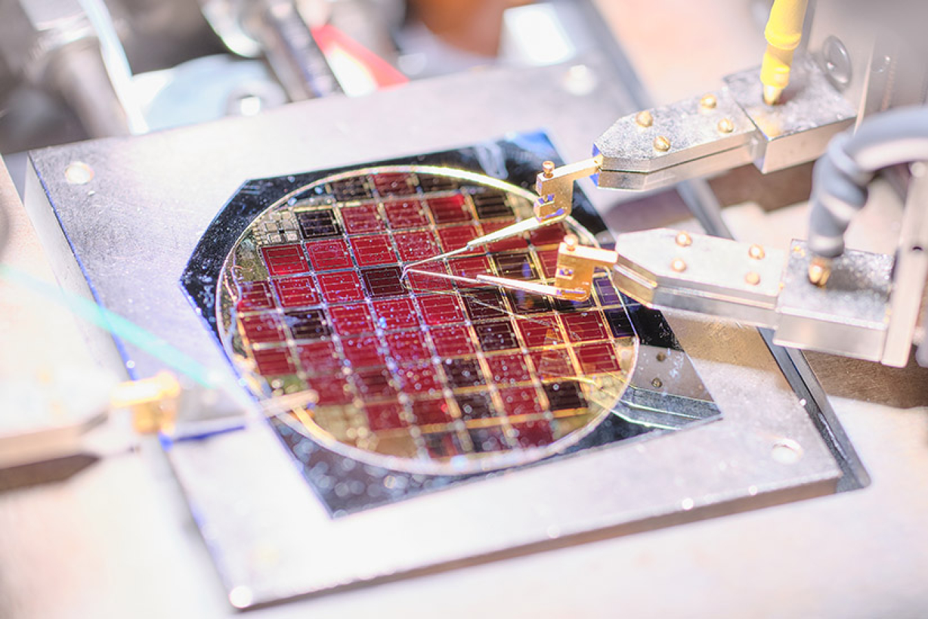 The near-record two-junction III-V solar cell glows red due to luminescence of the gallium indium phosphide top cell and indicates good material quality.