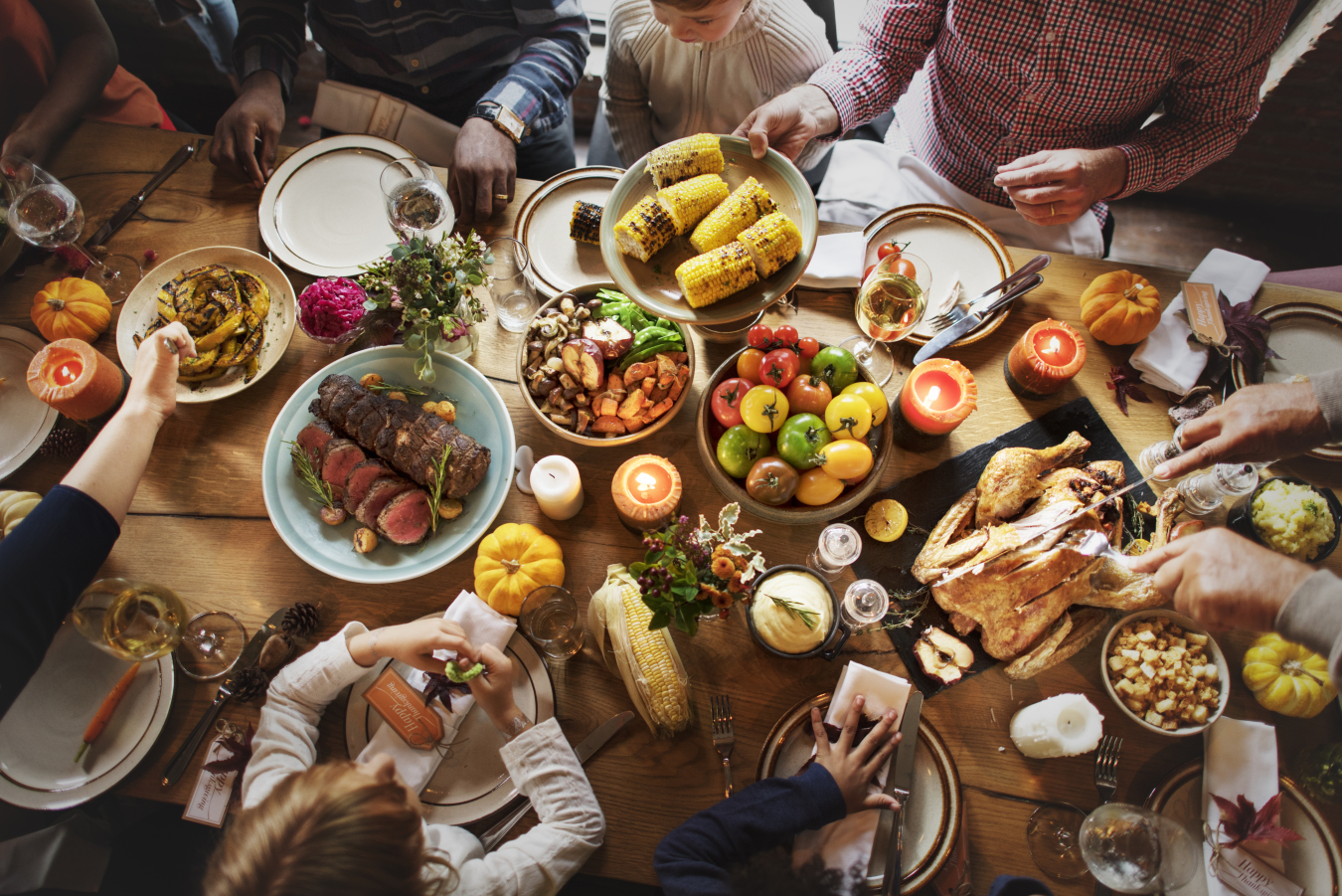 A group of people sit around a table full of food. 