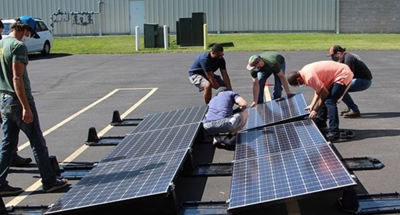 Photo of several people assembling solar panel arrays