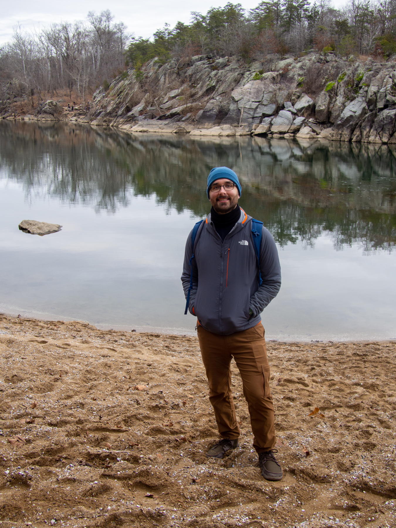 Jake Herb standing on a beach in front of a river.