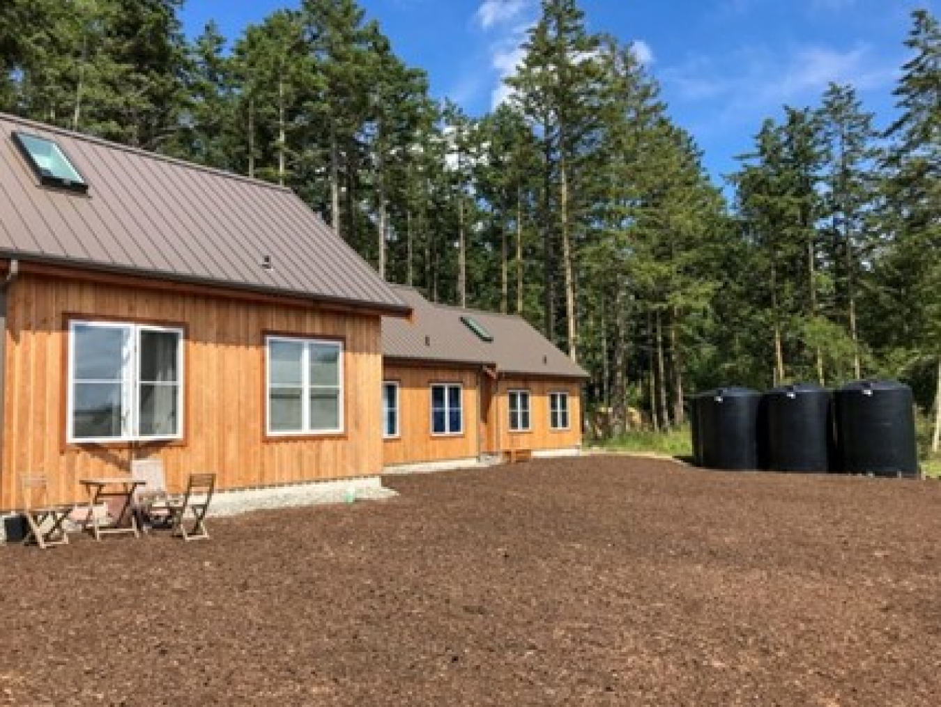 A wooden zero energy home with forests in the background