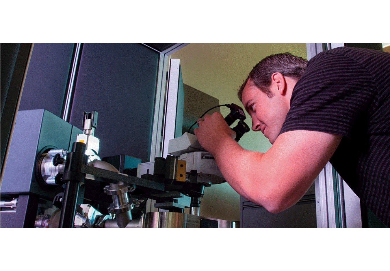 Colby Jensen looking into a microscope.