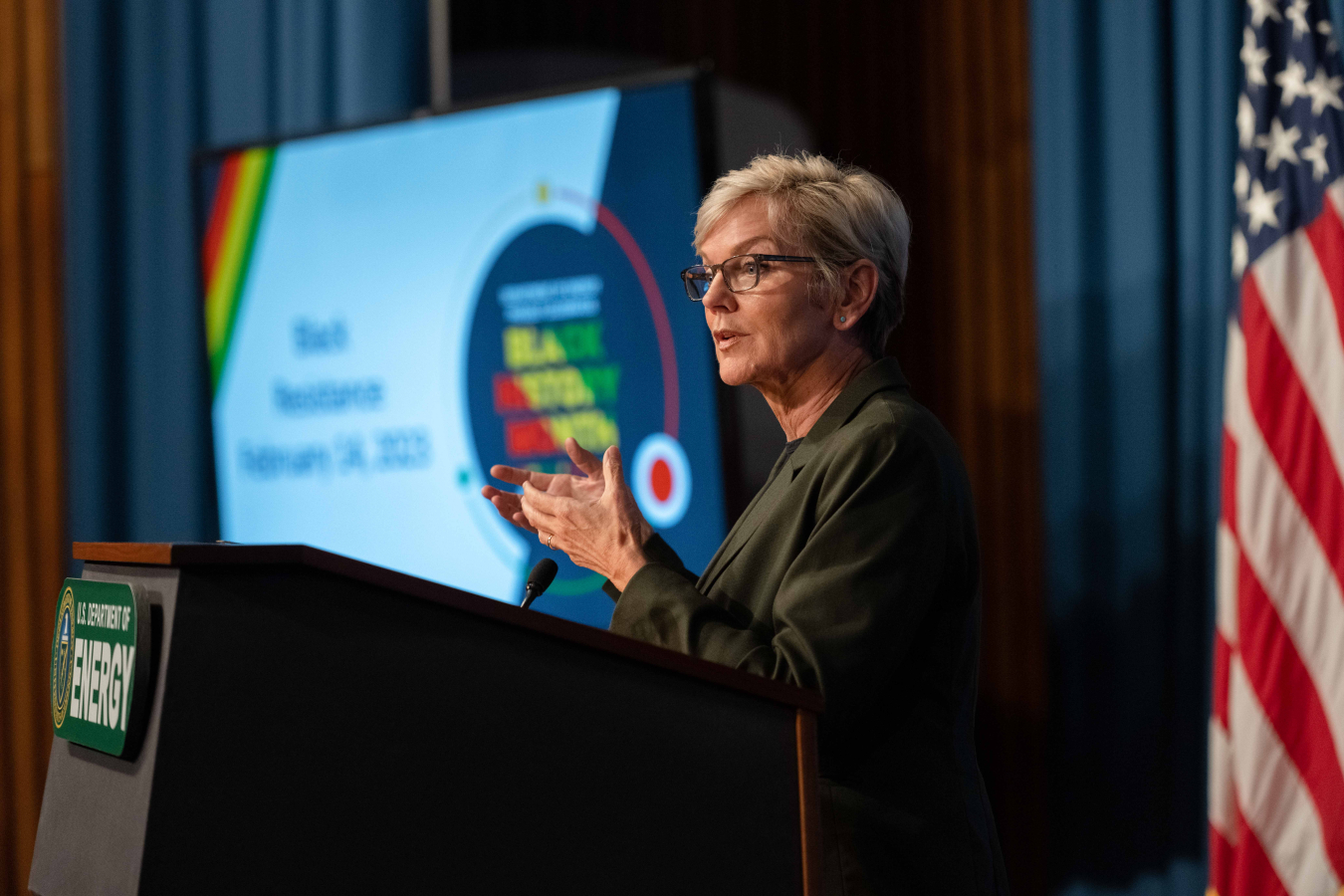Secretary Granholm standing behind a DOE podium.