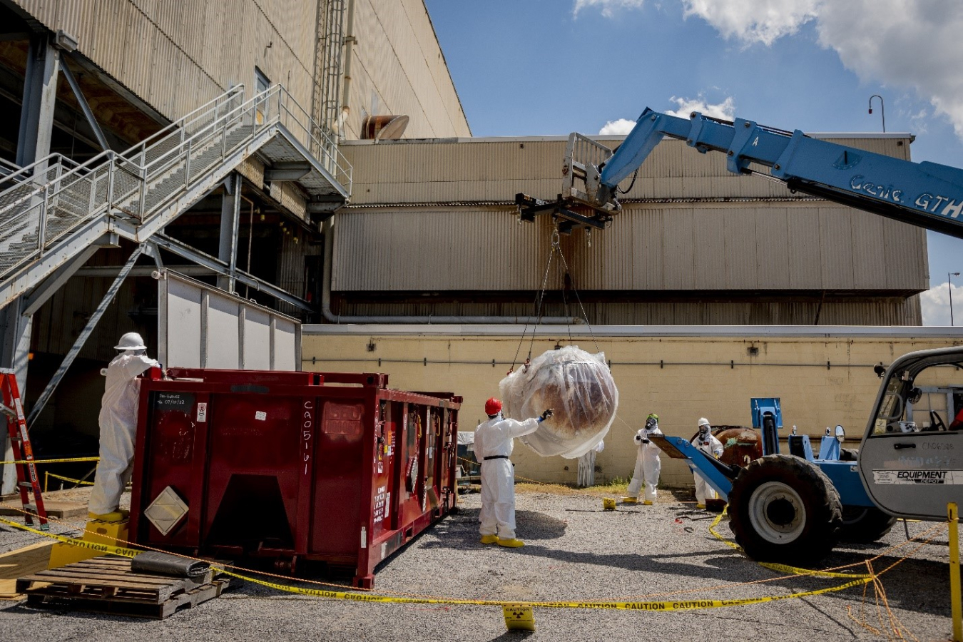 Paducah Site workers load cylinders into a waste container during C-333-A Feed Vaporization Facility deactivation activities.