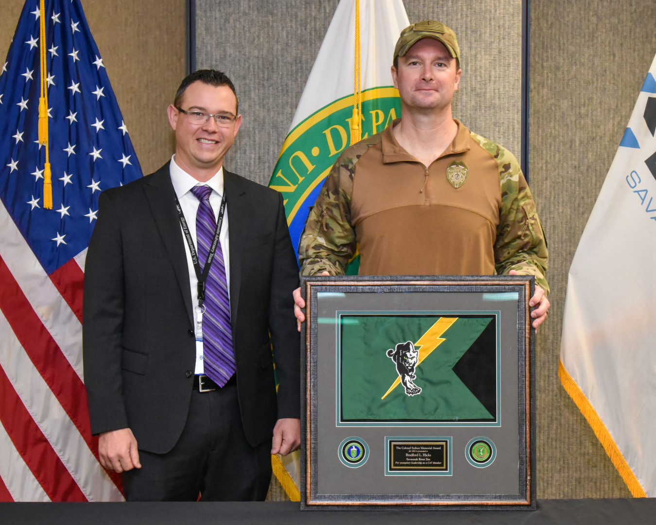 Centerra-SRS Security Police Officer III Brad Hicks received the Colonel Elliott P. Sydnor, Jr., Memorial Award from Anthony Taylor, director of the DOE Office of Safeguards Assessments and federal program manager for the Composite Adversary Team.