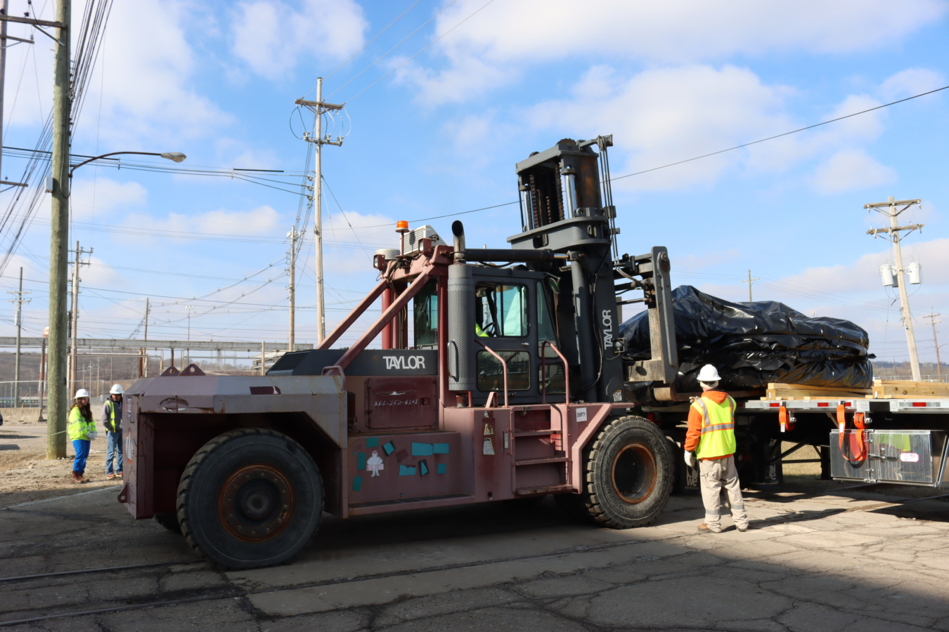Coolers from the X-333 Process Building are transported by flatbed truck to a demolition pad where the X-326 Process Building once stood.
