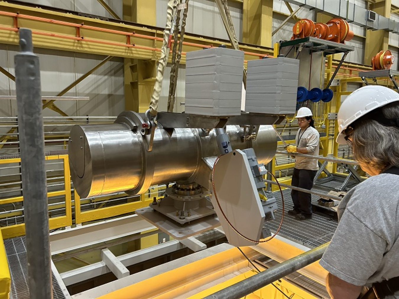 Workers with EM contractor Central Plateau Cleanup Company install components for a mock-up at the Hanford Site’s Maintenance and Storage Facility. A full-scale mock-up is being built to allow workers to test equipment and practice processes before moving nearly 2,000 radioactive capsules from an underwater basin to interim dry storage.