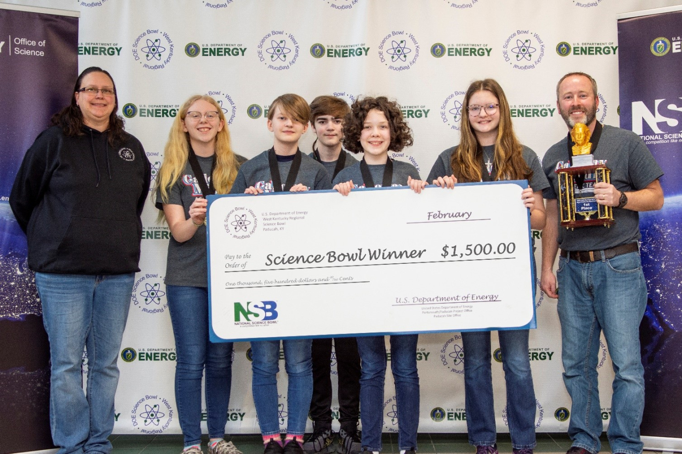 Calloway County Middle School recently won the DOE West Kentucky Regional Science Bowl. Pictured from left are EM Acting Paducah Site Lead April Ladd, Lillie Russell, Ella Martin, Aiden Hooper, Ava Bogard, Sarah Doyle and Coach Scott Pile.
