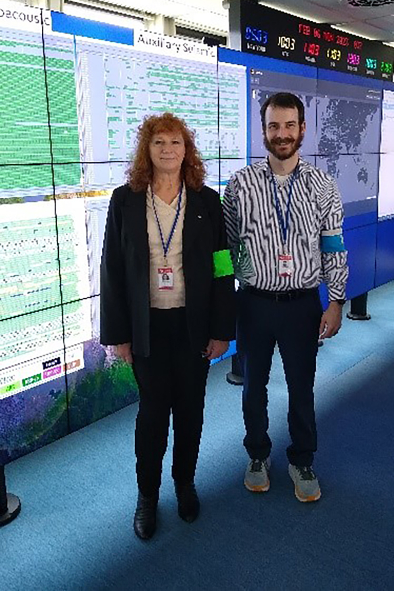 A man and a woman standing in a control room.