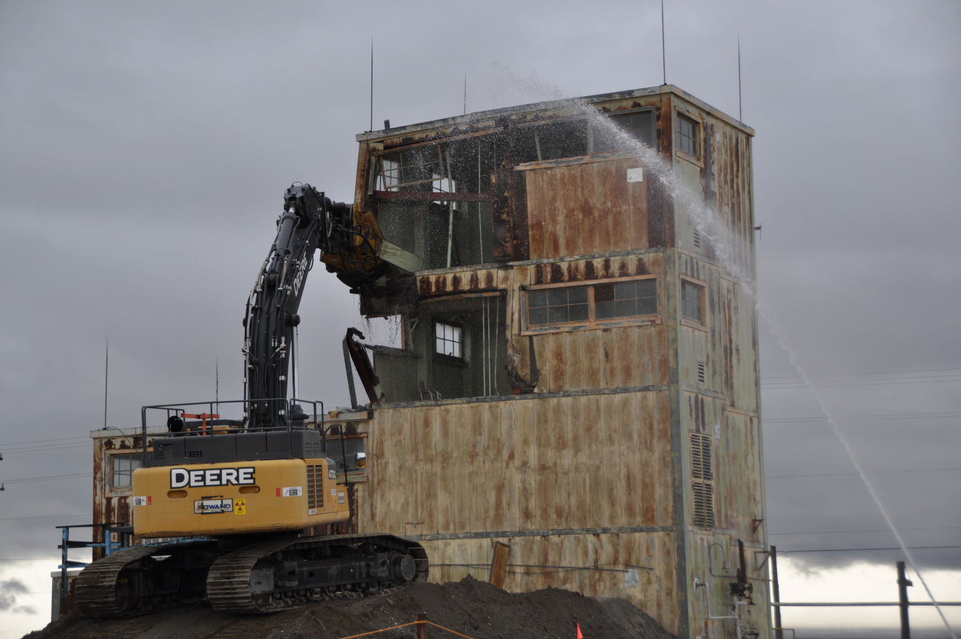 Workers with EM contractor Central Plateau Cleanup Company constructed a dirt ramp to allow an excavator to pick apart the four-story Solvent Handling Building on the Hanford Site.
