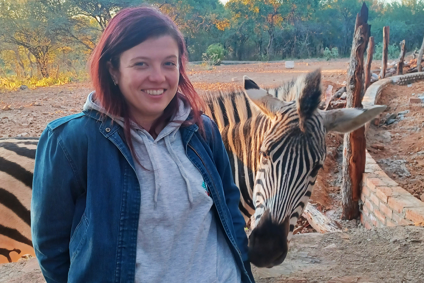 A portrait of Alina Smyslova next to a zebra.