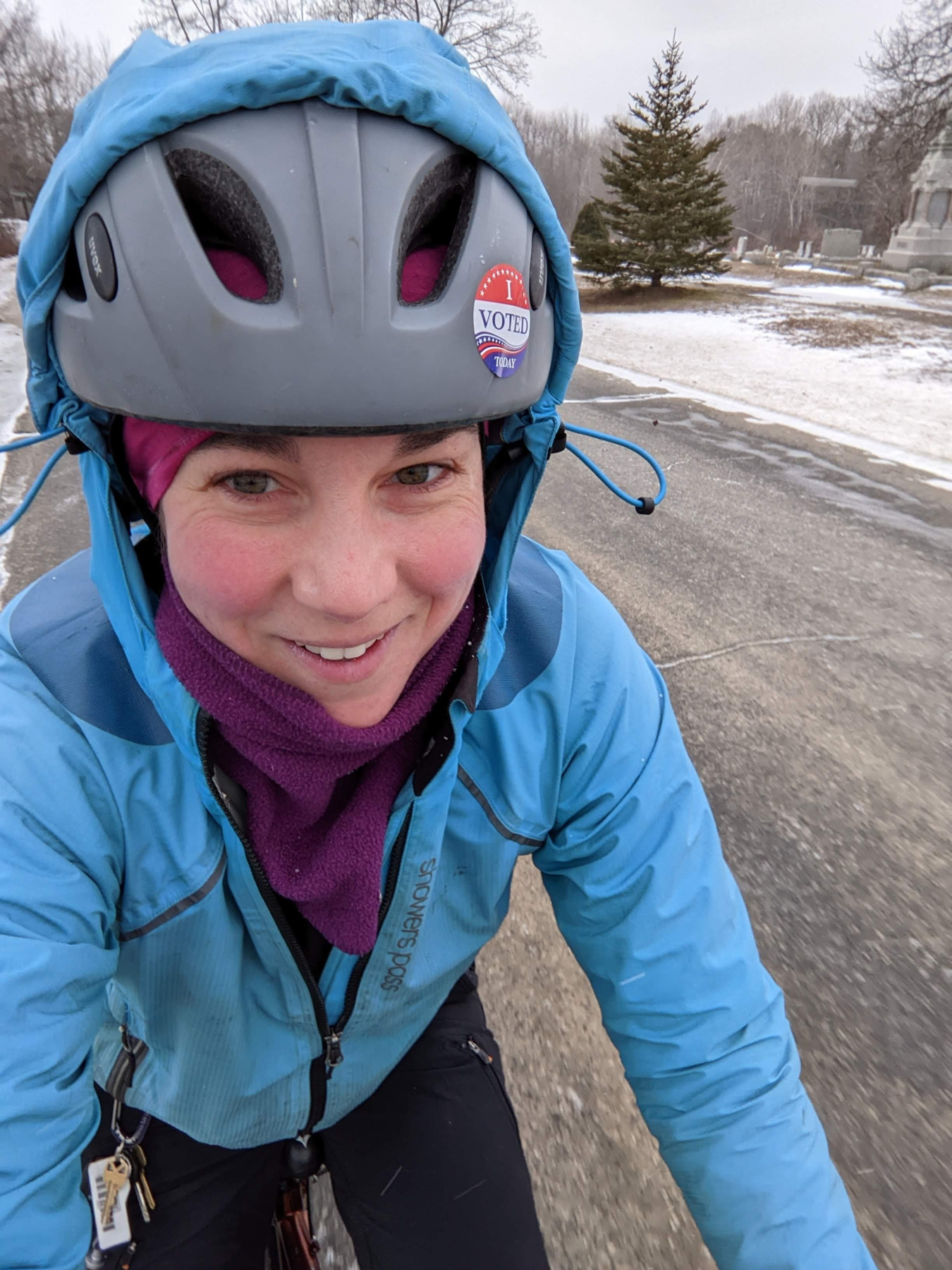 Emma smiles while riding a bike down a road in the snow.