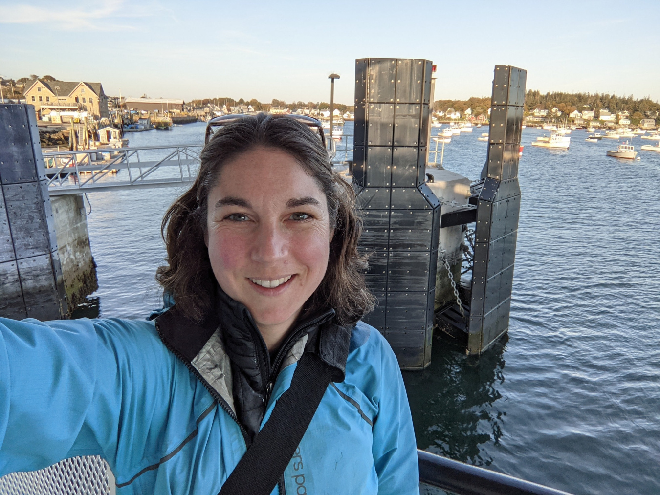Emma Wendt standing on the deck of a ferry still in a harbor with a metal and rubber ferry docking station in the background.