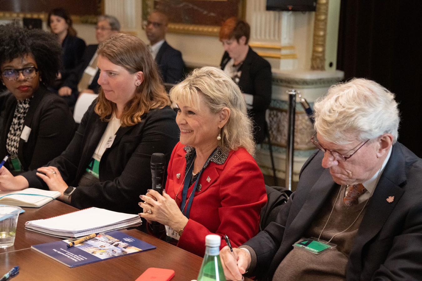 Individuals sitting at a table during a meeting.