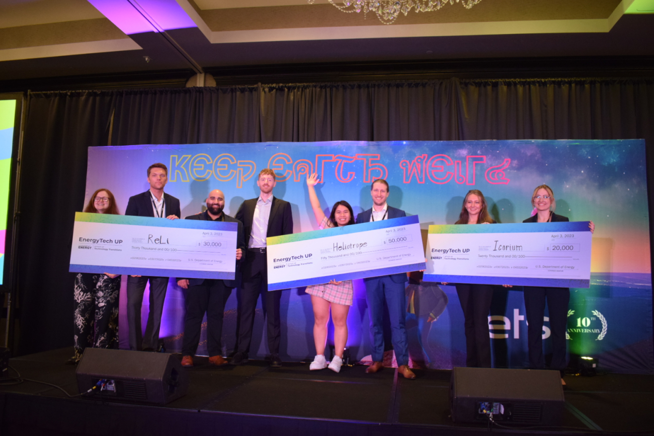 Photo of teams representing the three winners of the Energy Tech University Prize holding oversized checks representing award amounts