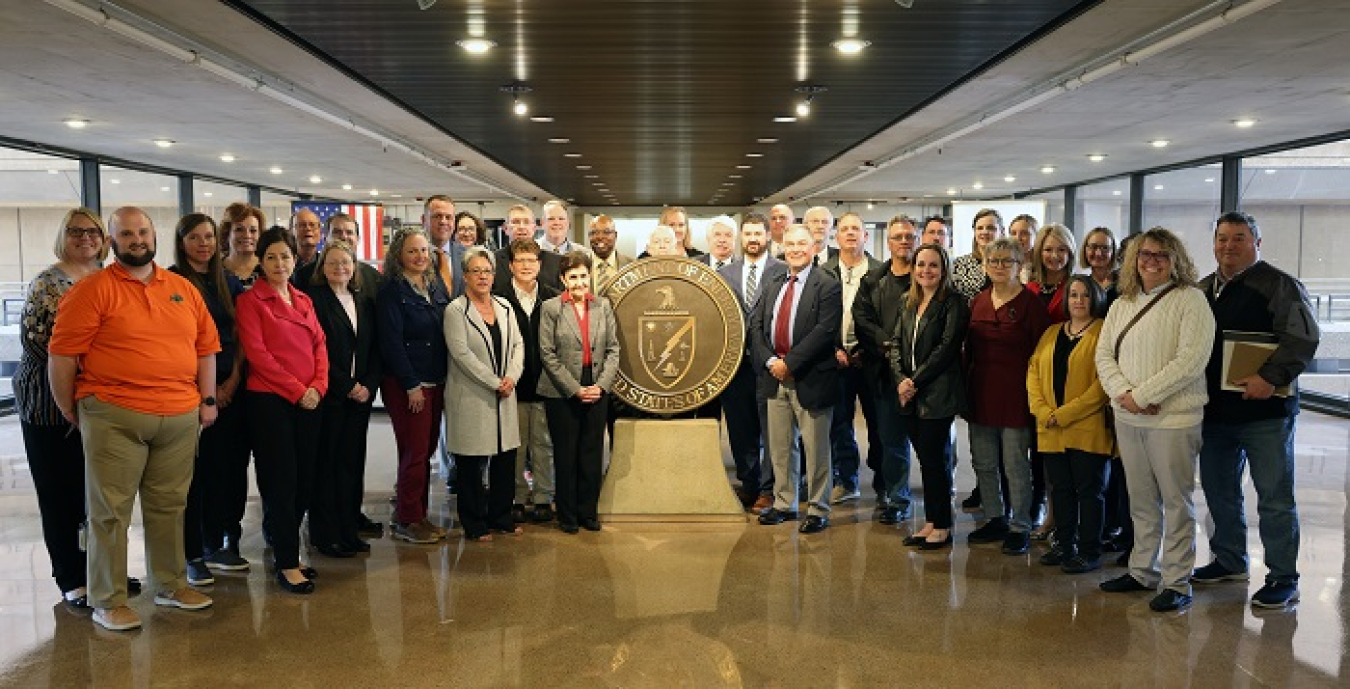 Representatives from all eight local Site-Specific Advisory Boards (SSAB) and staff who attended the recent EM SSAB National Chairs meeting gather for a photo at the DOE headquarters James Forrestal Building. EM Principal Deputy Assistant Secretary Jeff Avery is also pictured at center.