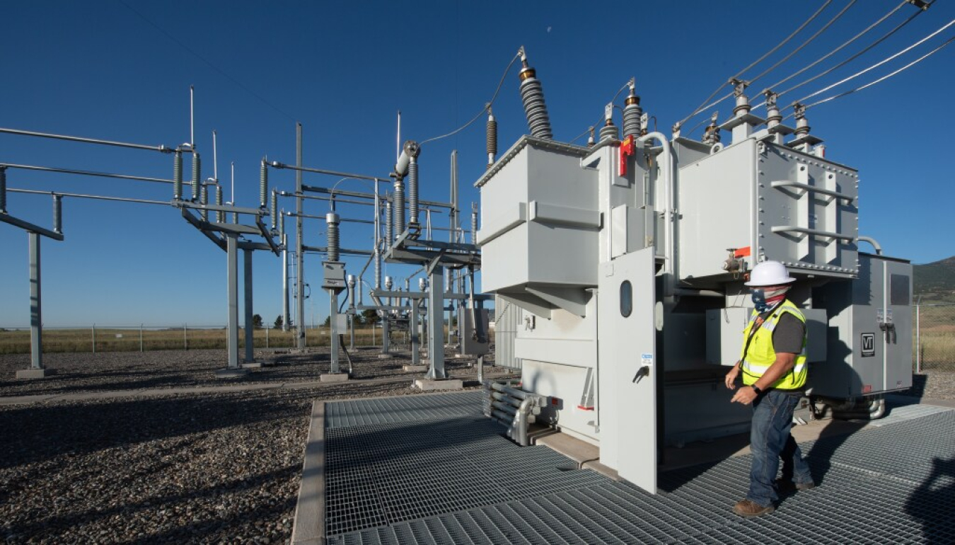 a utility worker inspects a substation.