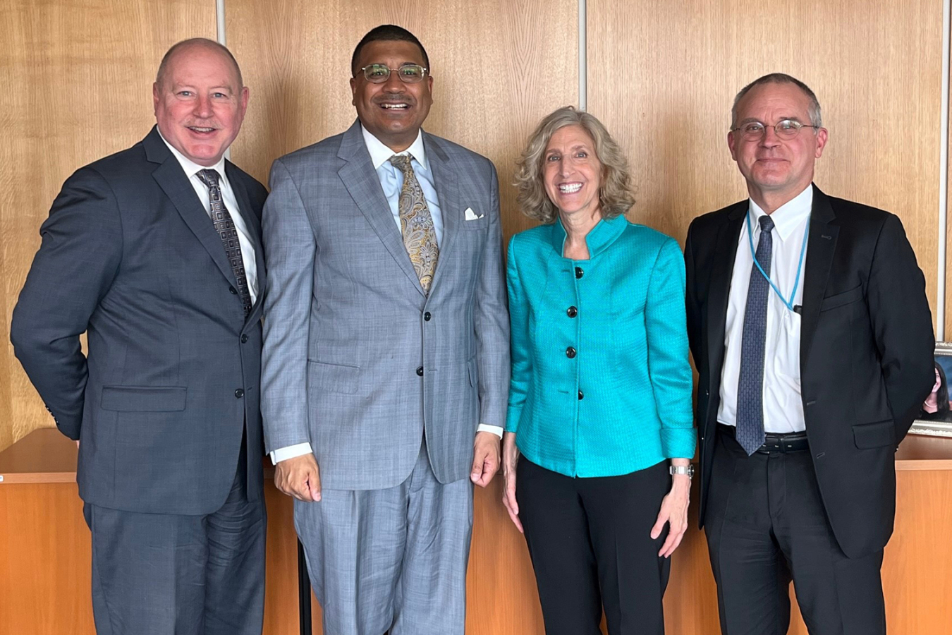 Three men and a woman pose for a photo.