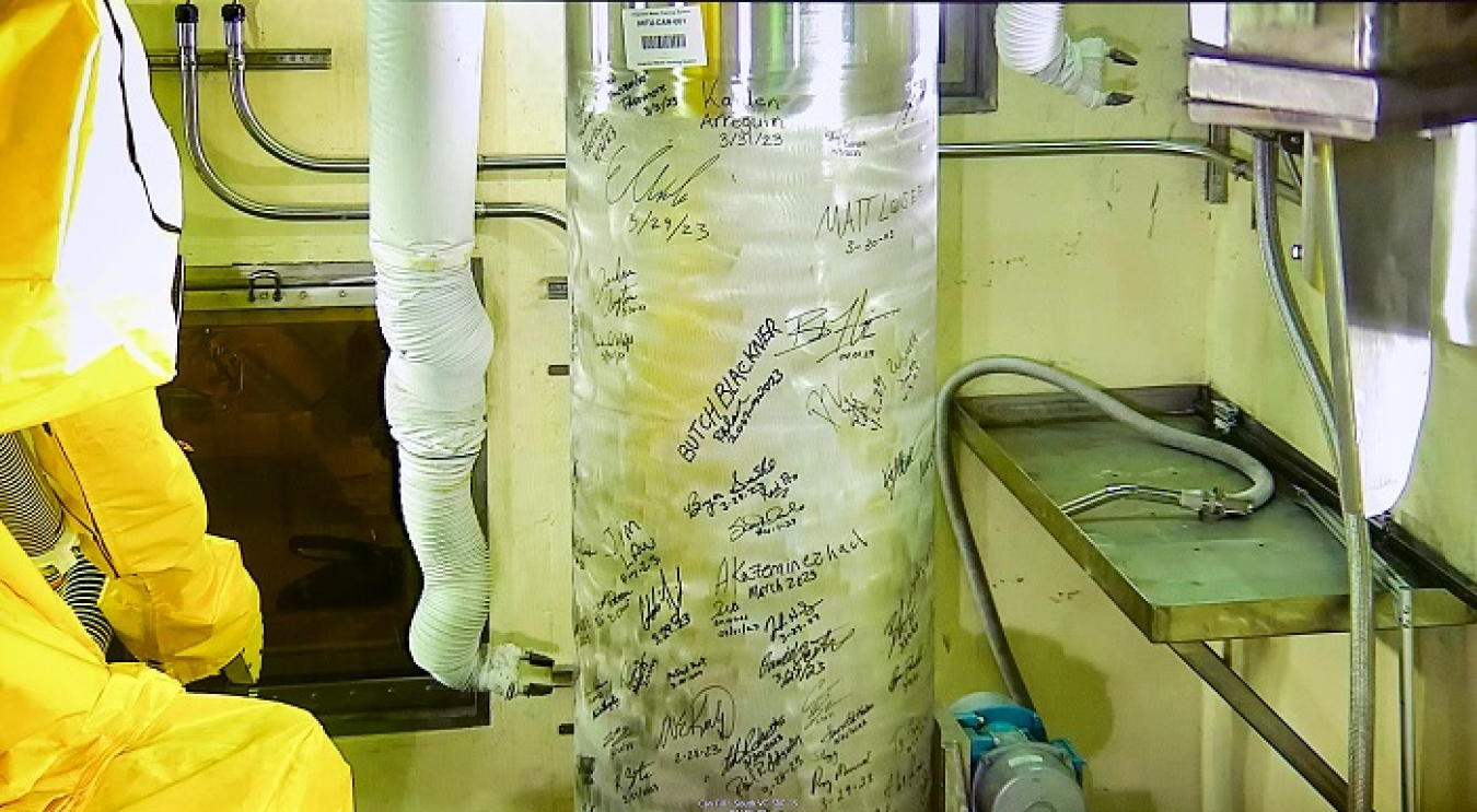 EM management, Integrated Waste Treatment Unit employees and others signed the first stainless steel canister prior to crews filling it with sodium-bearing waste and simulant. Once filled, that canister and 15 others were placed in a concrete vault for storage.