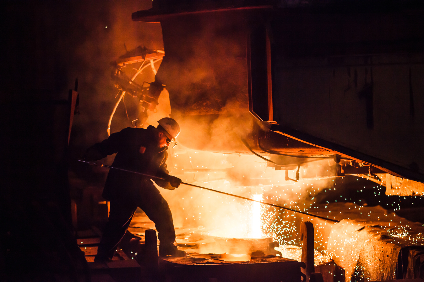 A worker puts something in a fire. 