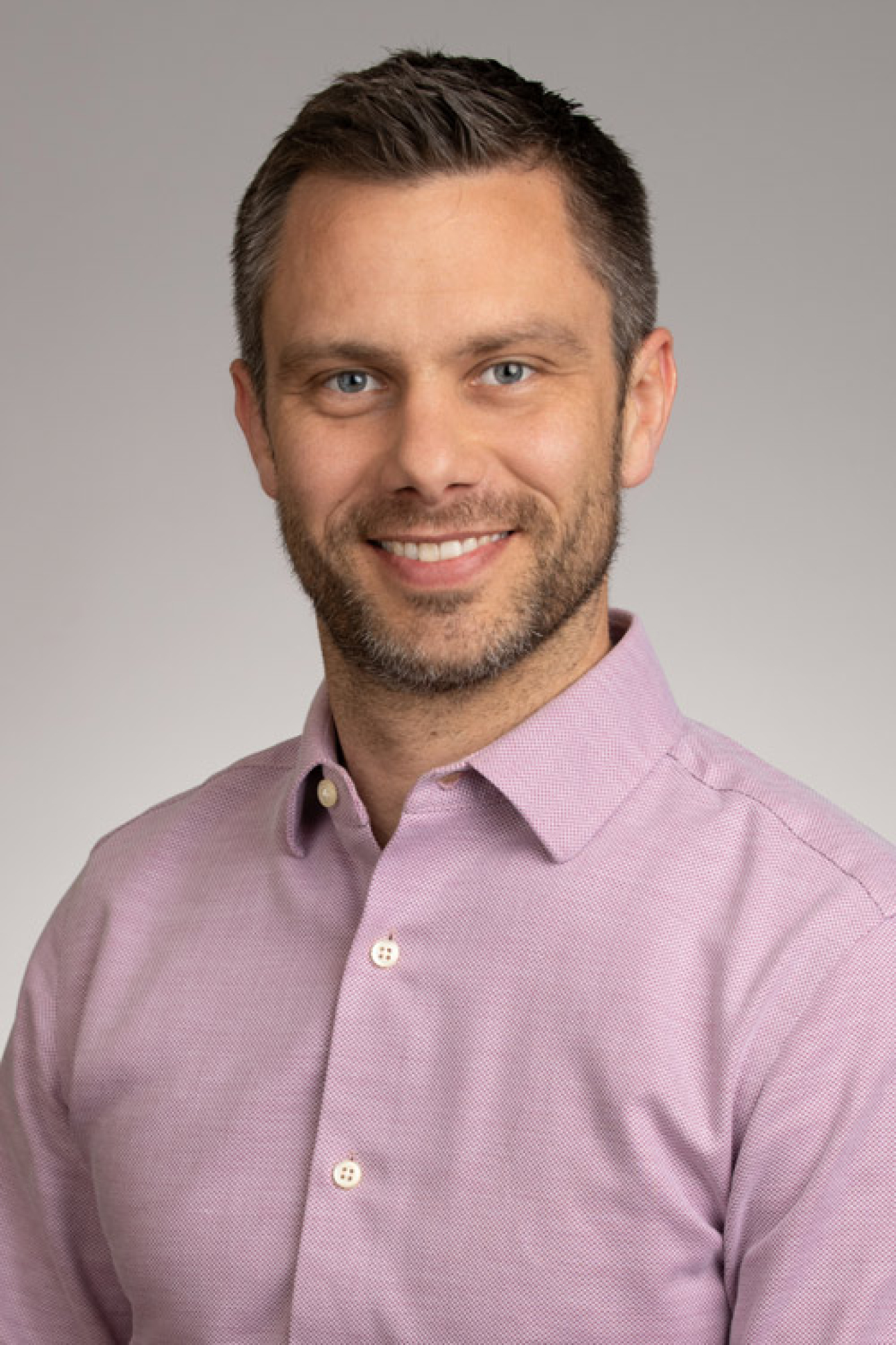Portrait of Mike Vehar in a pink button down shirt.