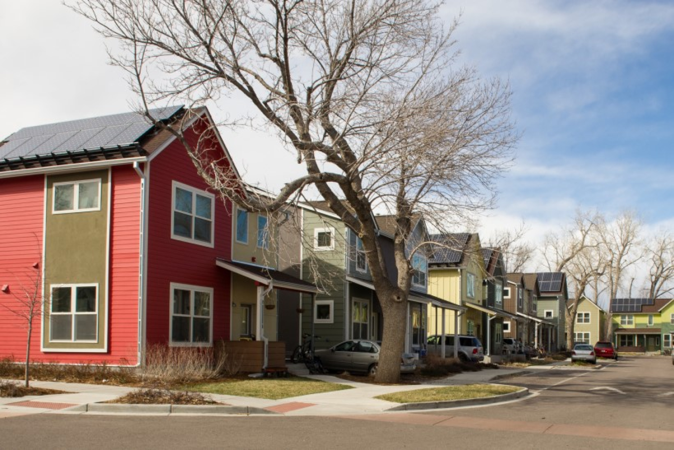 A residential street with homes and trees lining it on each side.