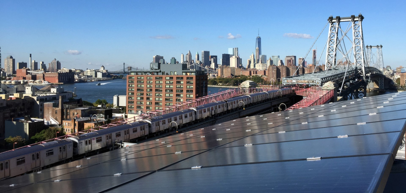 Cropped image of solar panels looking over a city with a bridge and a river