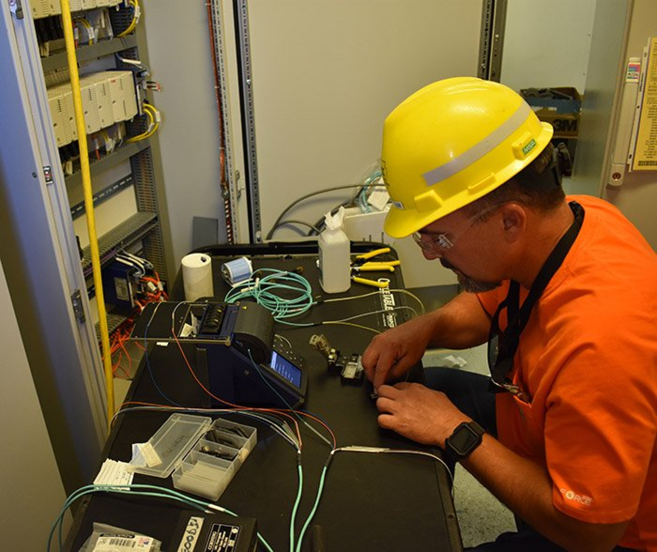 An electrician installs fiber optic cables inside an electrical powerhouse for the Effluent Management Facility at the Hanford Site’s Waste Treatment and Immobilization Plant.