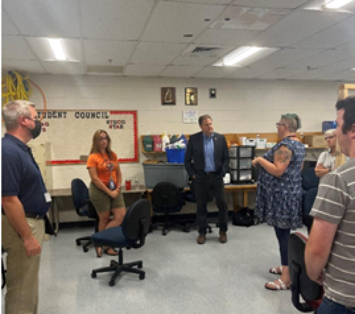 New Hampshire Governor Chris Sununu talks with Campbell High School staff in a classroom