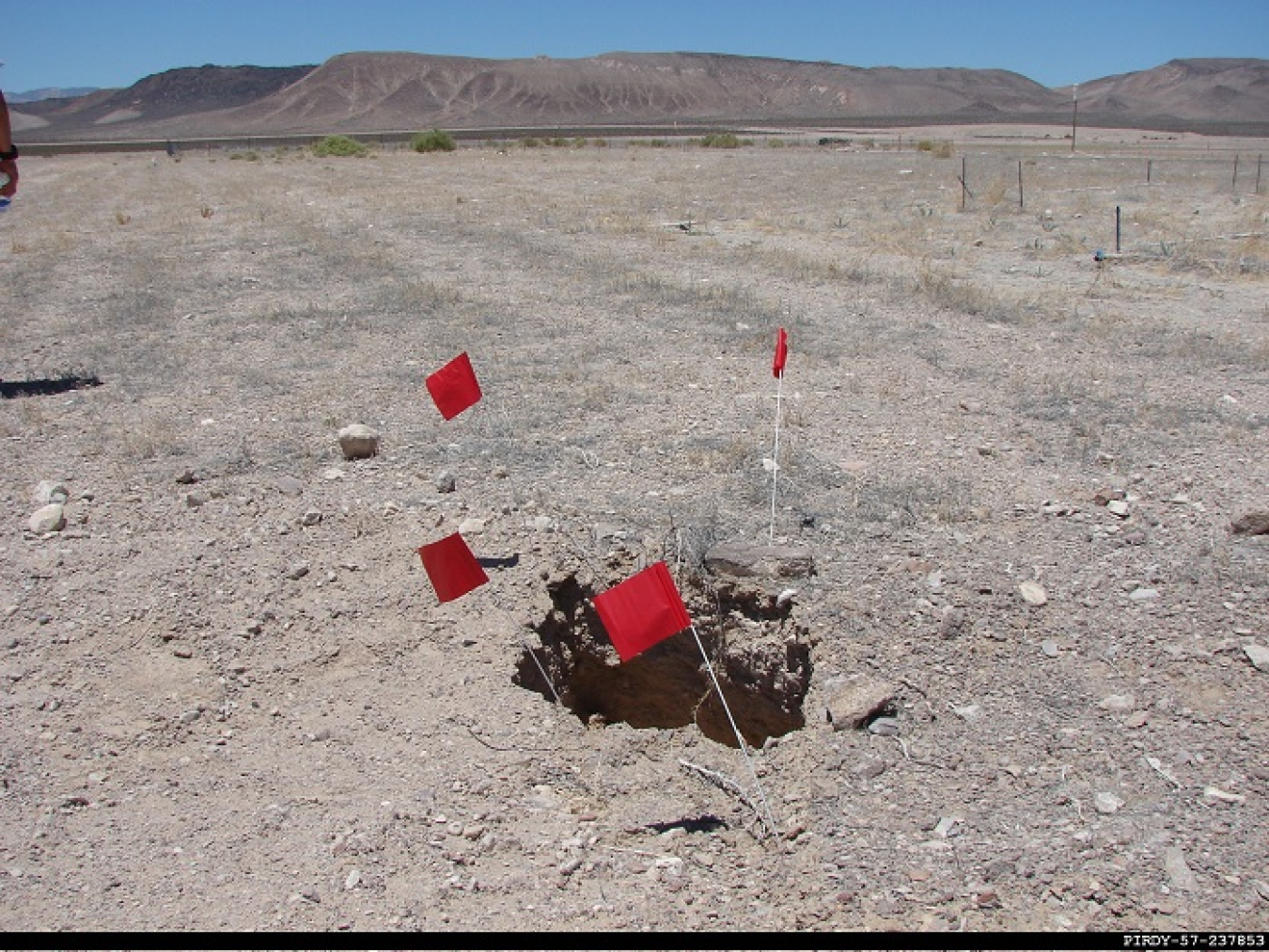A look at a subsidence hole — a little dip in the earth’s surface that forms over time — marked with flags.