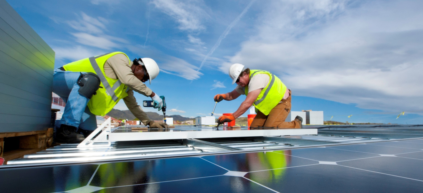 workers installing rooftop solar panels.