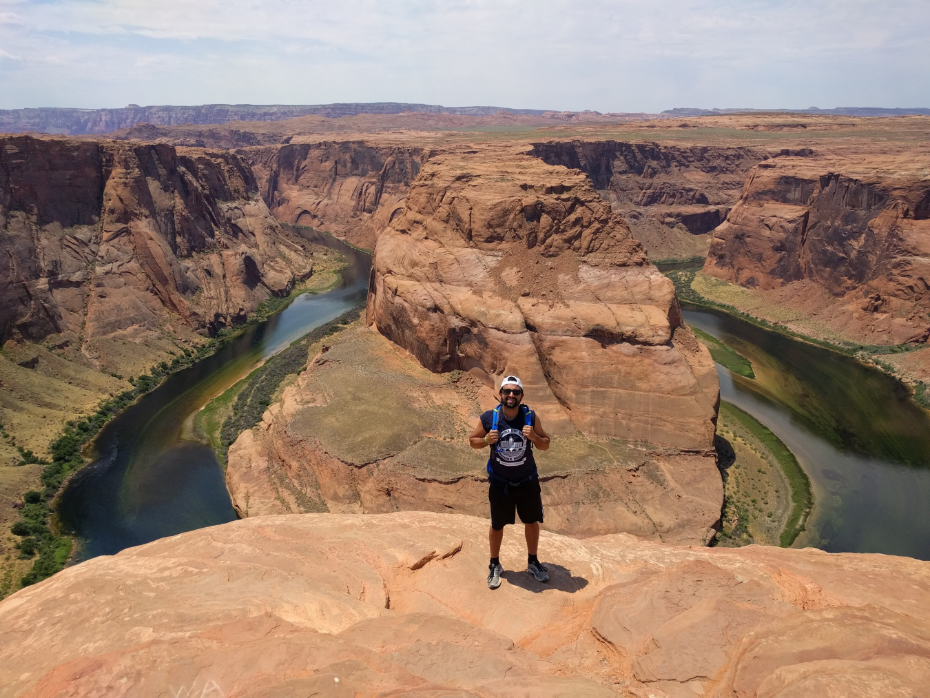 Mirko Musa standing on top of a canyon with a river winding through a valley underneath