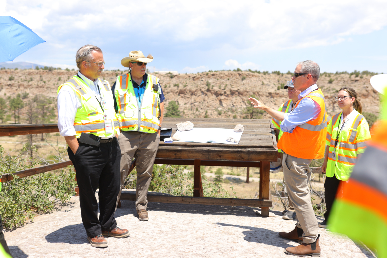 EM Senior Advisor William “Ike” White visited Mortandad Canyon to view progress in addressing groundwater contamination at Los Alamos National Laboratory. During the tour, White addressed questions from Los Alamos County representatives on the hexavalent chromium plume. From left: Michael Mikolanis, EM Los Alamos Field Office manager; Troy Thomson, Newport News Nuclear BWXT Los Alamos Environmental Remediation Program manager; White; Philo Shelton, director, Los Alamos County Department of Public Utilities;