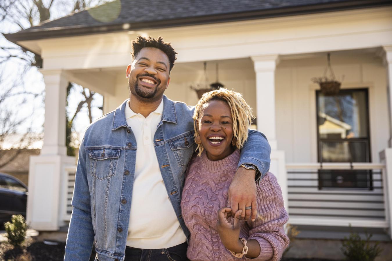 Smiling couple in front of their home.